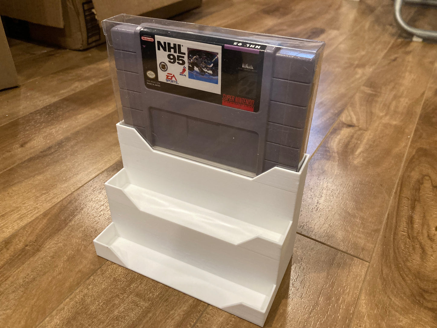 Display for SNES games in plastic PET protectors - Holds 3 games - White color - Perfect condition